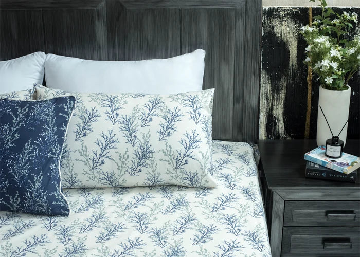 White cotton bed sheet with blue botanical branch pattern; two coordinating pillow shams