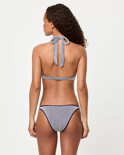 Back view of a model wearing the LSPACE midnight blue Isa Bikini Top and Suzi Bikini bottom showing the halter neck tie and band back closure in navy stripe.