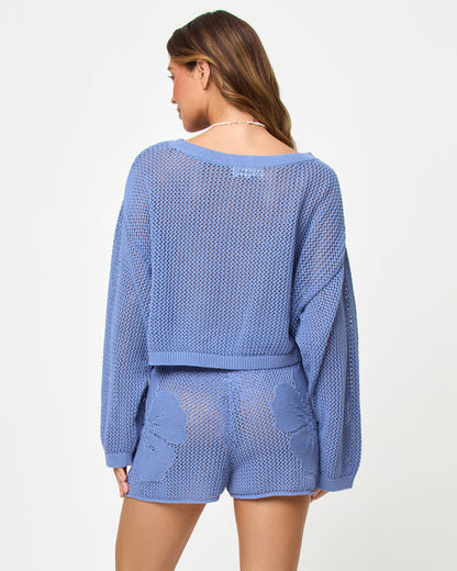 Back view of a model wearing the LSPACE Island Time Short in Chambray, styled with the matching Island Time Sweater, showing the floral crochet pattern and open-knit construction.