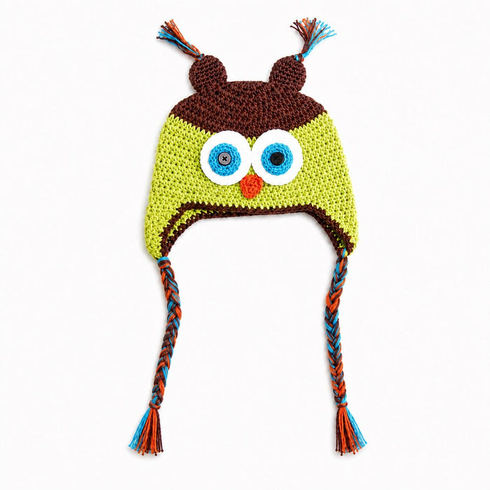 Crocheted owl hat with large embroidered eyes, a small orange beak, brown ear covers, and braided ear ties in blue, orange, and brown on a white background.