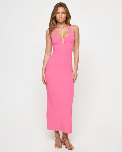 Front view of a model wearing the LSPACE La Femme Dress in begonia, a form-fitting maxi halter dress with a plunging V-neckline in a vibrant pink.