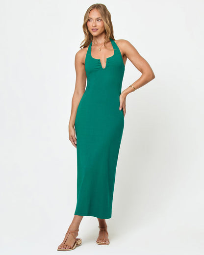 Front view of a model wearing the LSPACE La Femme Dress in Isle on a white background, a fitted emerald green ribbed knit halter maxi dress with a plunge V-notch neckline.