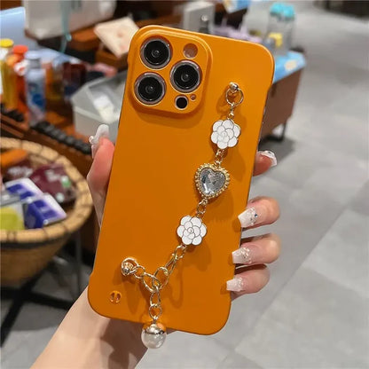 a woman holding an orange phone case with a flower design