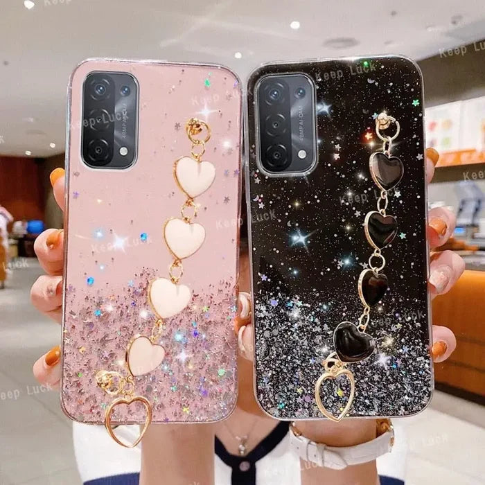 a woman holding two phone cases with a heart and a keychai