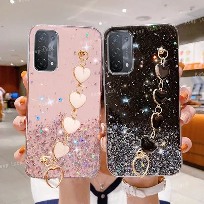 a woman holding two phone cases with a heart and a keychai