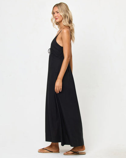 Side view of a model wearing the LSPACE Mabel Maxi Dress in black, showing the deep V-neckline, spaghetti straps, and flowing A-line silhouette.