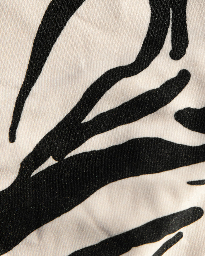 Close-up of cream and black abstract floral print fabric used in the LSPACE Heavy Petal Rocky Bikini Bottom.