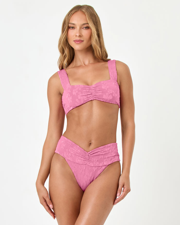 Front view of a model wearing the LSPACE hottest pink Marlee Bikini Top, paired with the Bardot Bikini Bottom.