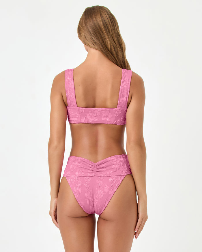 Back view of a model wearing the LSPACE hottest pink Marlee Bikini Top, paired with the Bardot Bikini Bottom.