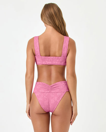 Back view of a model wearing the LSPACE hottest pink Marlee Bikini Top, paired with the Bardot Bikini Bottom.