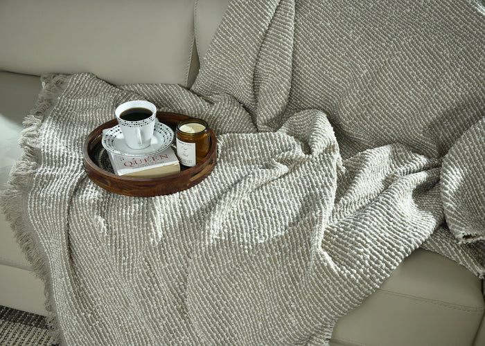 Folded brown knitted throw blanket with textured ribbed knit pattern