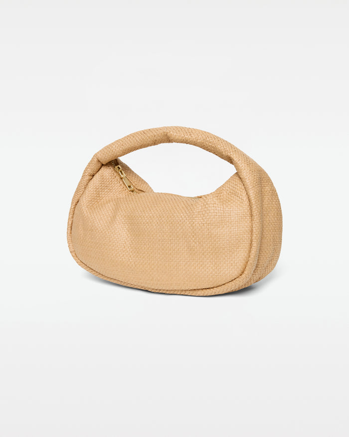 Angled view of the Mendoza Bag in natural showing the woven raffia texture, gold zipper closure, and curved handle.