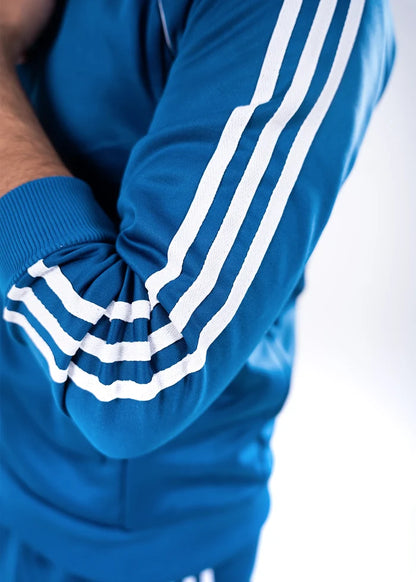 Blue jogger pant cuffs with white triple stripe detailing and ribbed knit hem