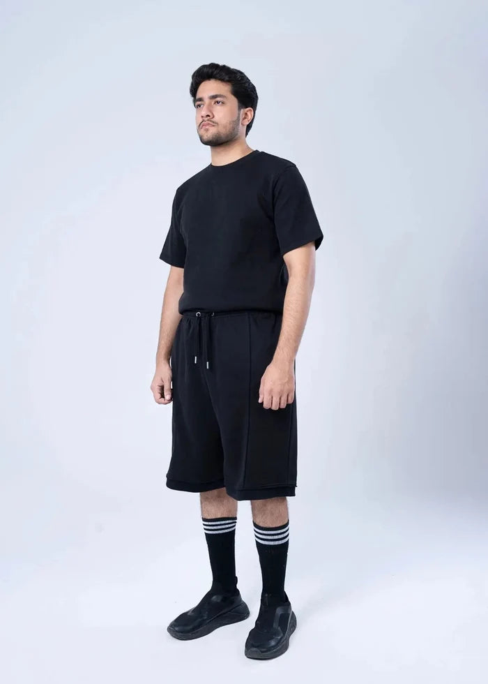 Black terry-knit shorts, front drawstring detail, straight knee-length cut