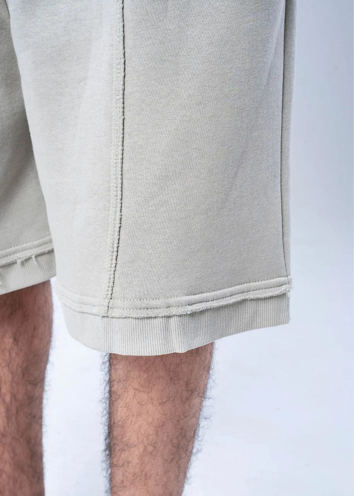 Men's casual knit shorts hem close-up, light beige stitching and ribbed cuff