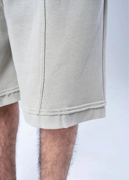 Men's casual knit shorts hem close-up, light beige stitching and ribbed cuff