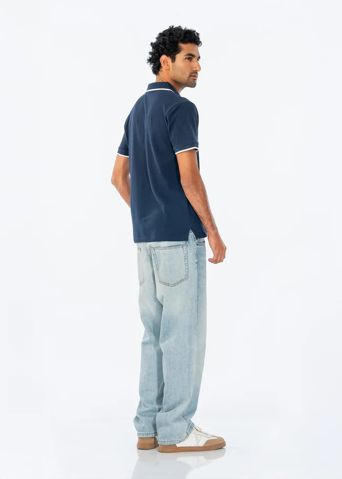 Navy polo shirt from side view with white-trim sleeve cuffs and collar