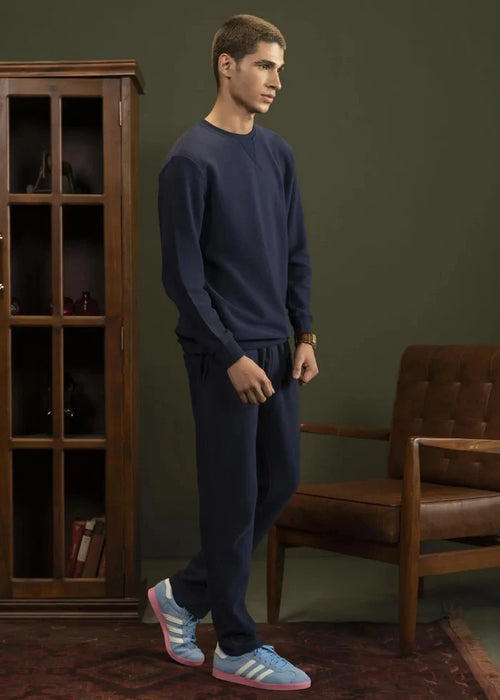 Navy crewneck sweatshirt, long sleeves and ribbed hem, worn with matching joggers