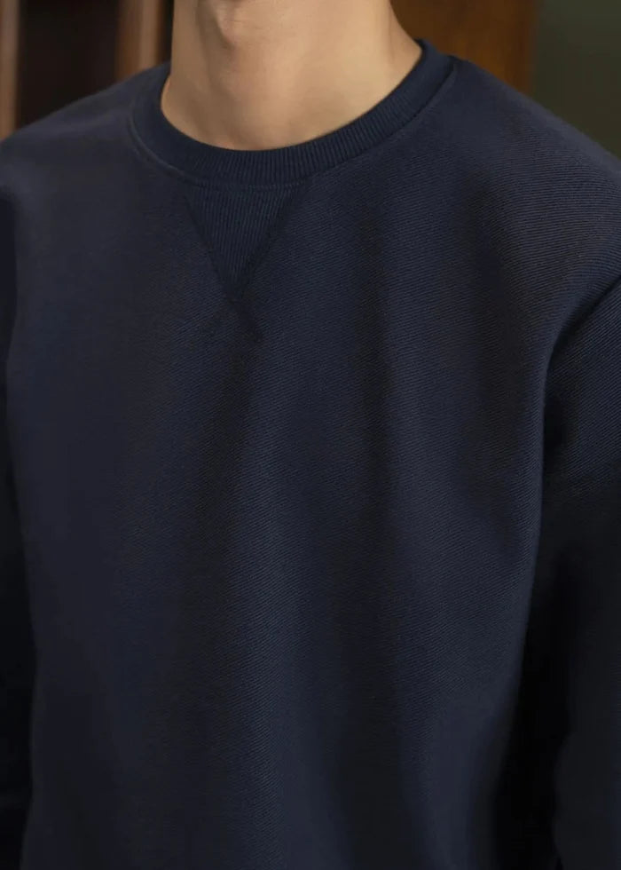 Navy crewneck pullover sweatshirt with ribbed collar and smooth long sleeves
