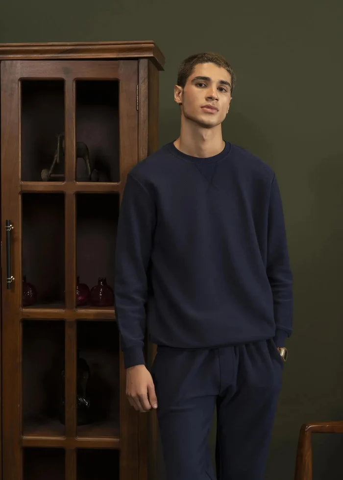 Navy crewneck sweatshirt with ribbed neckline, cuffs, and hem