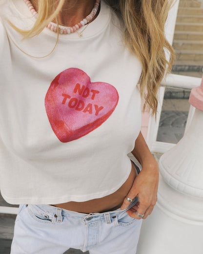 Close-up of the LSPACE Merci Baby Tee in Not Today, highlighting the oversized pink candy heart graphic reading "Not Today" on the white cropped front.