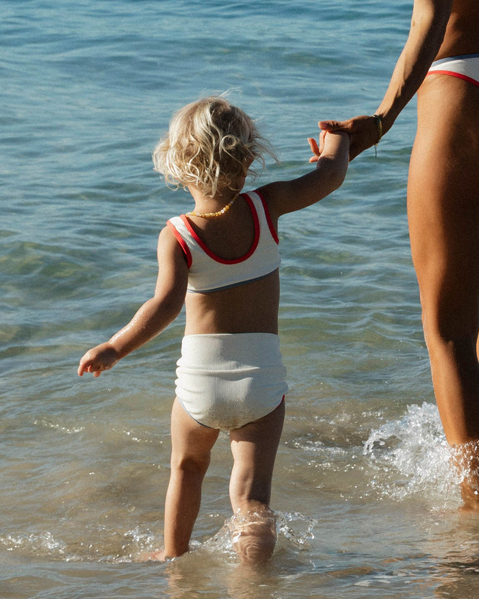 LSPACE Mini Me set in Cream-Pout-Chambray, lifestyle/editorial view on model wading in the ocean.