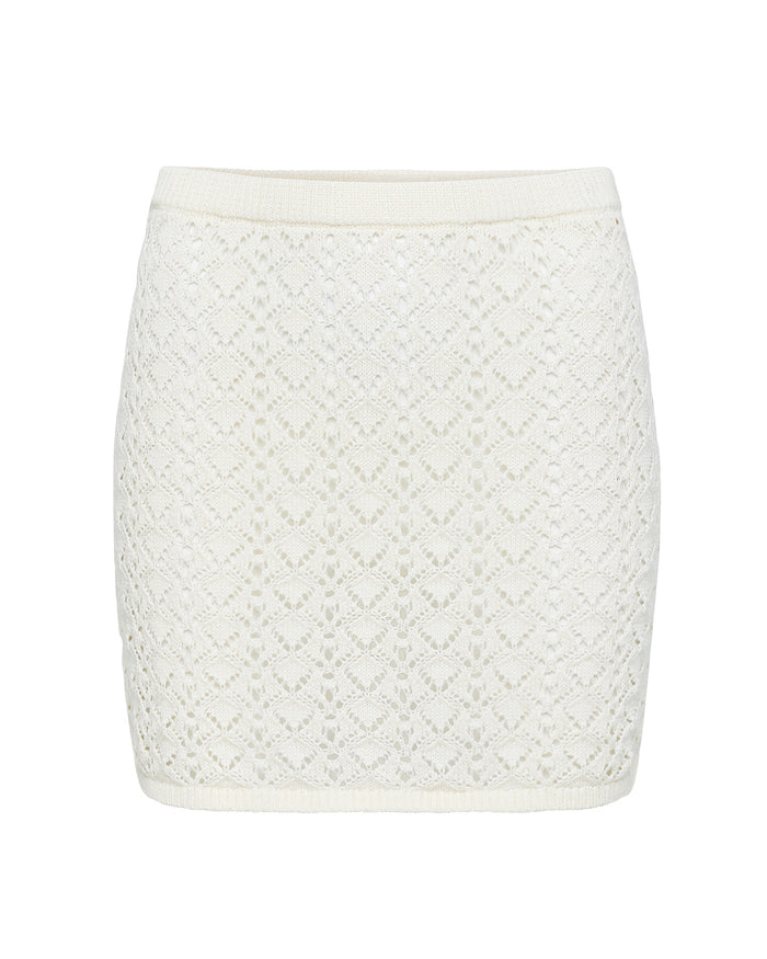 Off-model view of the LSPACE Nova Skirt in cream, displayed on a white background to show the cream crochet diamond pattern and ribbed waistband of the mini skirt.