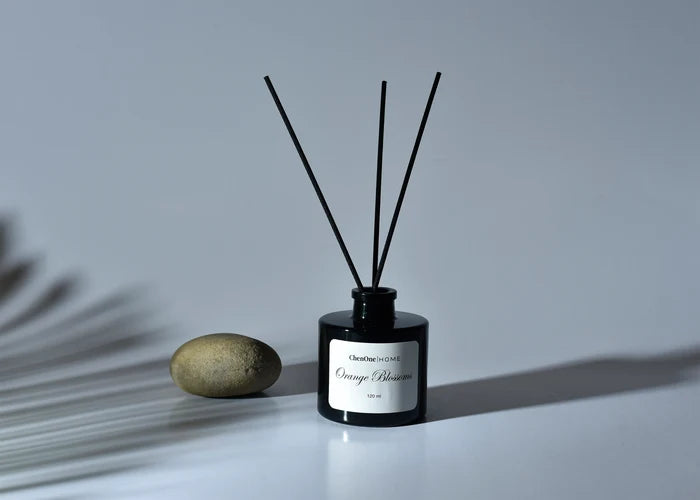 Black reed diffuser bottle with three dark reeds and label