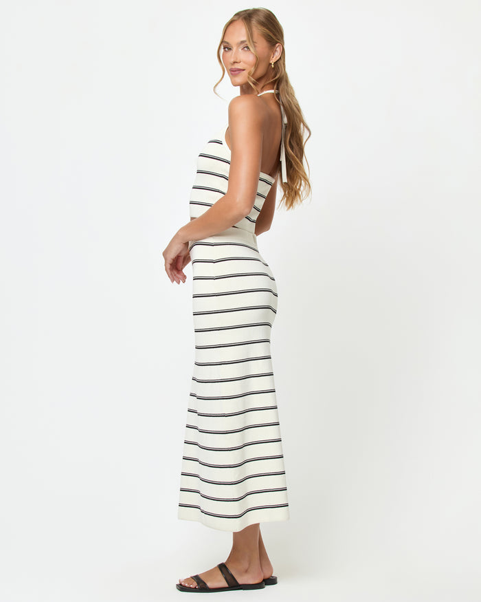 Side view of a model wearing the LSPACE Positano Top in mykonos stripe, showing the open-back halter design with cream and black horizontal stripes, styled with the matching Ravello Skirt.