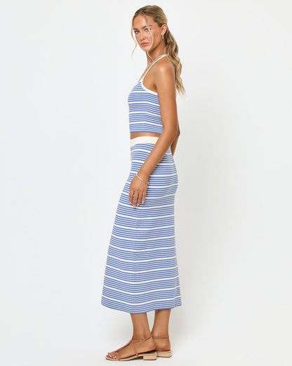Side view of a model wearing the LSPACE Positano Top and Ravello Skirt in outer banks stripe, a ribbed fitted fabric with blue and cream horizontal stripes.