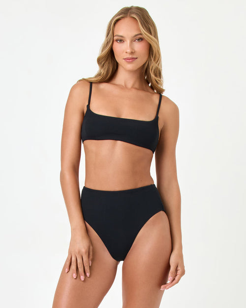 Front view of a model wearing the LSPACE black Presley Bikini Top with a square neckline and thin adjustable straps, styled with the matching Soleil Bikini Bottom.