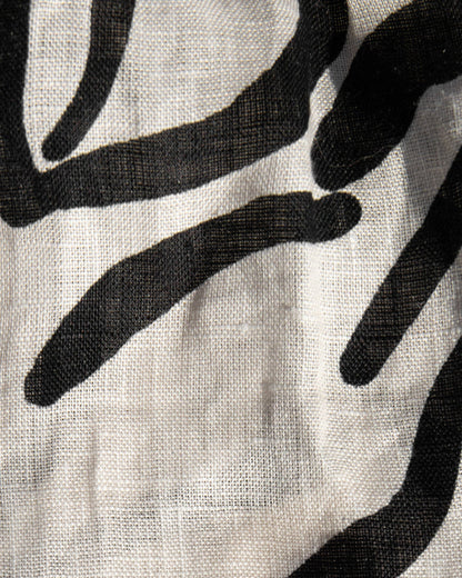 Close-up of the LSPACE Rio Tunic and Short in heavy petal, highlighting the linen fabric texture and bold black botanical brushstroke print on a cream background.