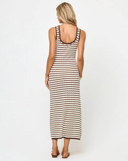 Back view of a model wearing the LSPACE Rosalie Maxi in cafe-cream, a fitted sleeveless knit maxi dress with cream and dark brown horizontal stripes and a scoop back.