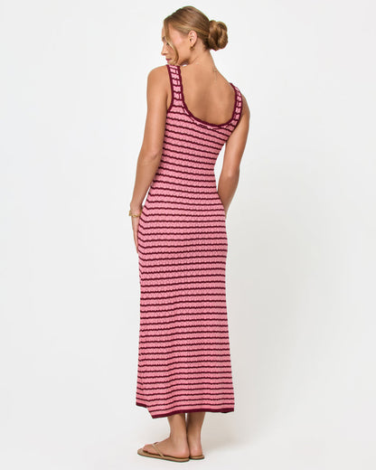 Back view of a model wearing the LSPACE Rosalie Maxi in strawberry stripe, a fitted sleeveless knit maxi dress with pink and burgundy horizontal stripes and an open U-back neckline.