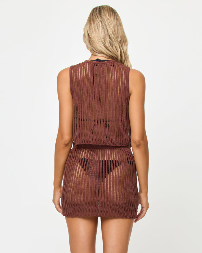 Back view of a model wearing the LSPACE Sander Skirt in cafe, showing the open crochet weave pattern of the mini skirt styled with the matching Sander Top.