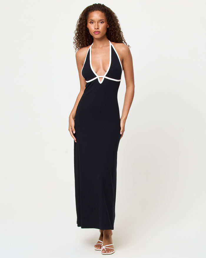 Front view of a model wearing the LSPACE Shea Maxi Dress in black-cream, a fitted halter maxi dress with a deep V-neckline and cream contrast trim straps.