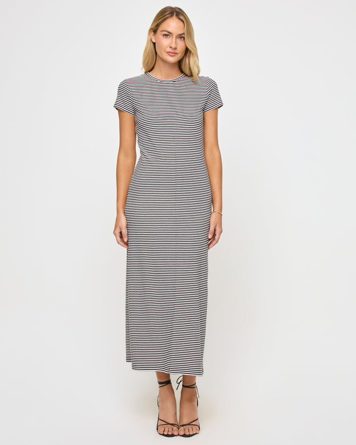 Front view of a model wearing the LSPACE Sloane Dress in black-cream, a fitted maxi dress with black and cream horizontal stripes, a crew neckline, and short cap sleeves.