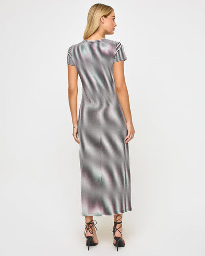 Back view of a model wearing the LSPACE Sloane Dress in black-cream, showing the fitted silhouette of the striped maxi dress with short sleeves.