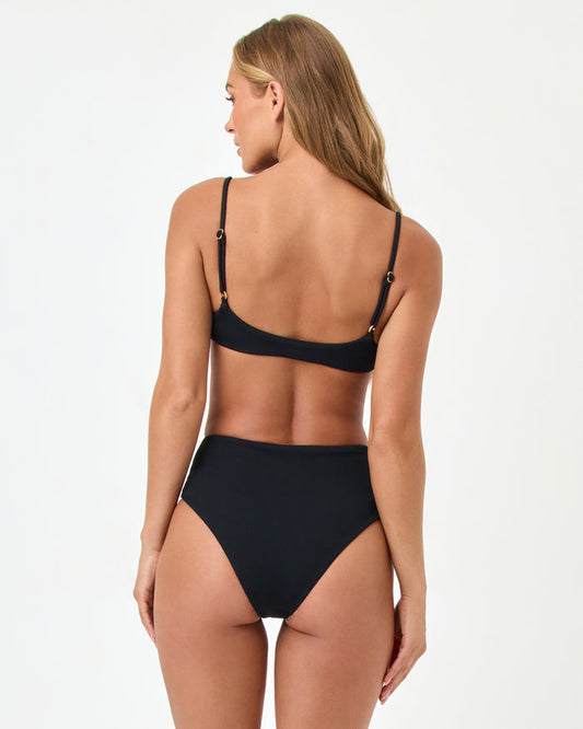 Back view of a model wearing the LSPACE black Soleil Bikini Bottom with the Presley Bikini Top.