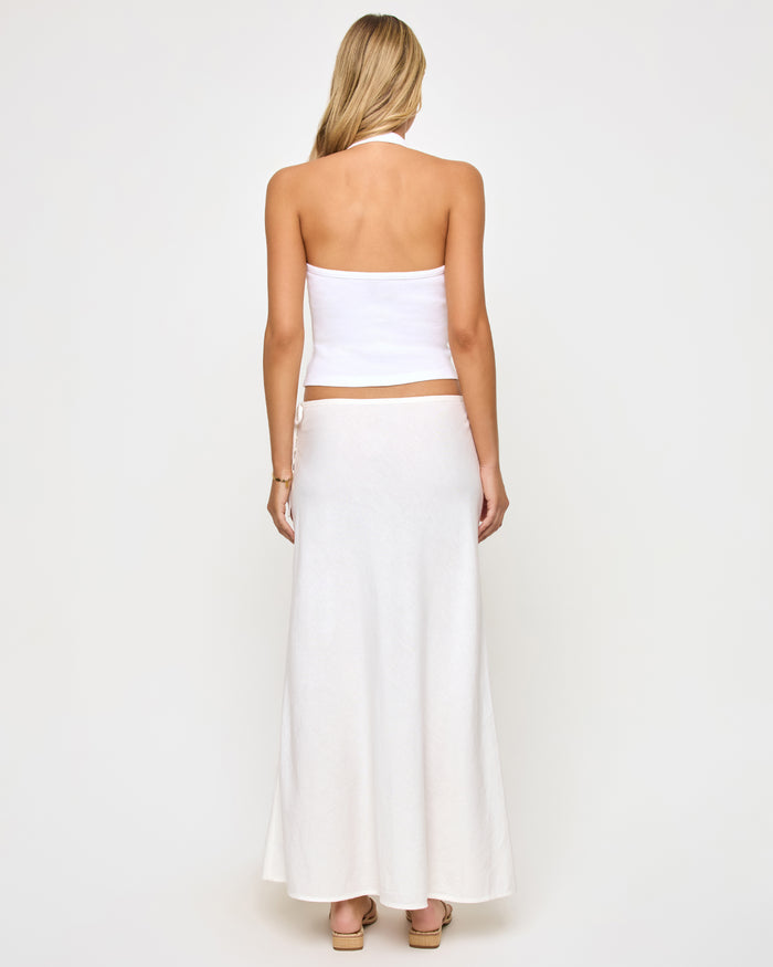 Back view of a model wearing the LSPACE Stop and Stare Skirt in cream, showing the clean back of the flowing maxi skirt.