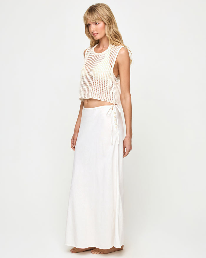 Side view of a model wearing the LSPACE Stop and Stare Skirt in cream, showing the side tie and button closure detail, paired with the Sander Top in cream.