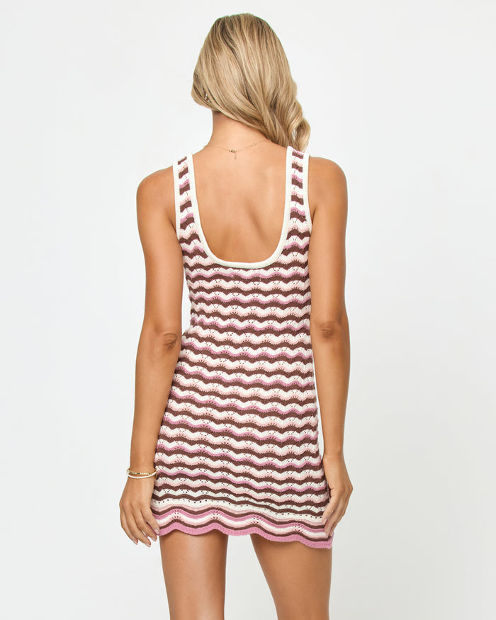 Back view of a model wearing the LSPACE Sunchaser Dress in neapolitan, showing the scoop back of the crochet tank mini dress with wavy stripe pattern.