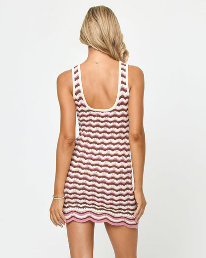 Back view of a model wearing the LSPACE Sunchaser Dress in neapolitan, showing the scoop back of the crochet tank mini dress with wavy stripe pattern.