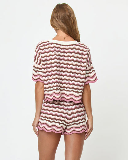 Back view on model of the LSPACE Sunchaser Short in Neapolitan, a crochet mini short in a brown, pink, and white wave pattern with scalloped hem, styled as a set with the matching Sunchaser Top.
