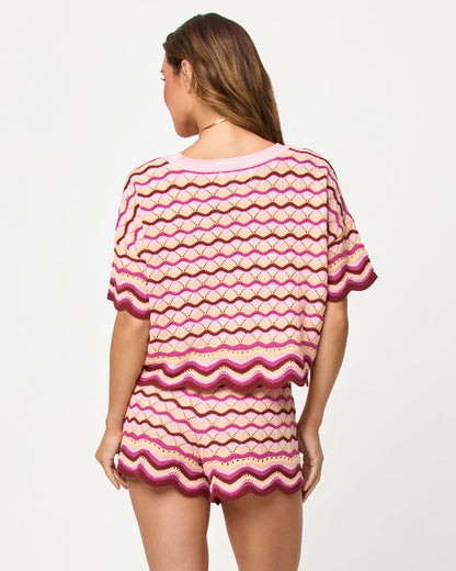 Back view of model wearing the LSPACE Sunchaser Top and Short in berry spritz, a crochet mini short with scalloped hem.