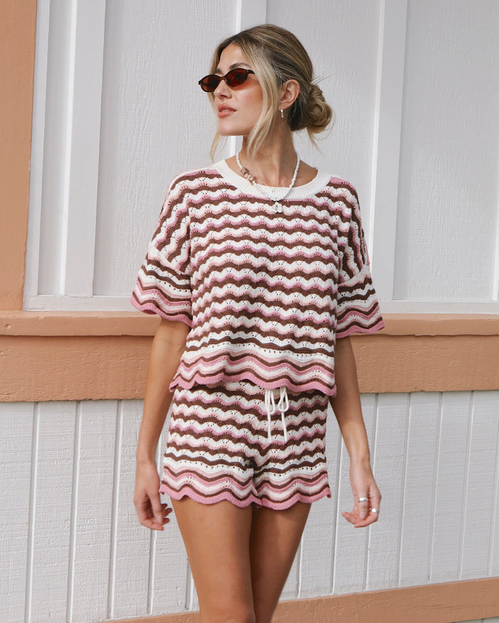 Front view on model of the LSPACE Sunchaser Top in Neapolitan, a short-sleeve crochet top in a brown, pink, and white wave pattern with scalloped hem, styled as a set with the matching Sunchaser Short.