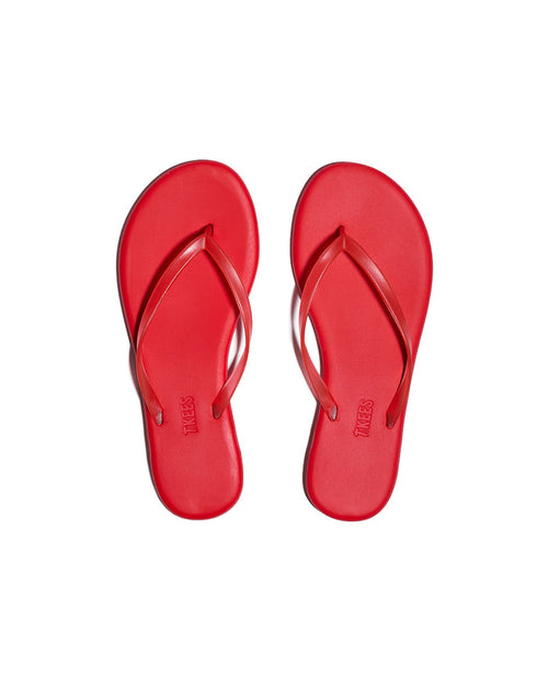 Top-down view of both red TKEES Aqua Sandals with slim thong strap and TKEES logo on footbed.
