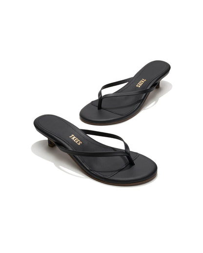 Angled view of both black sable leather TKEES Julia Kitten Heel thong sandals with TKEES logo.