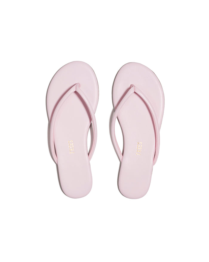 Top-down view of both powder pink TKEES Tubular Lily flip flops with TKEES logo on footbed.