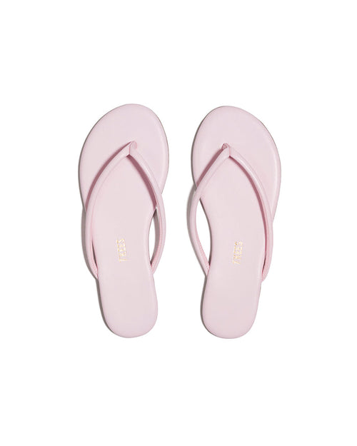 Top-down view of both powder pink TKEES Tubular Lily flip flops with TKEES logo on footbed.
